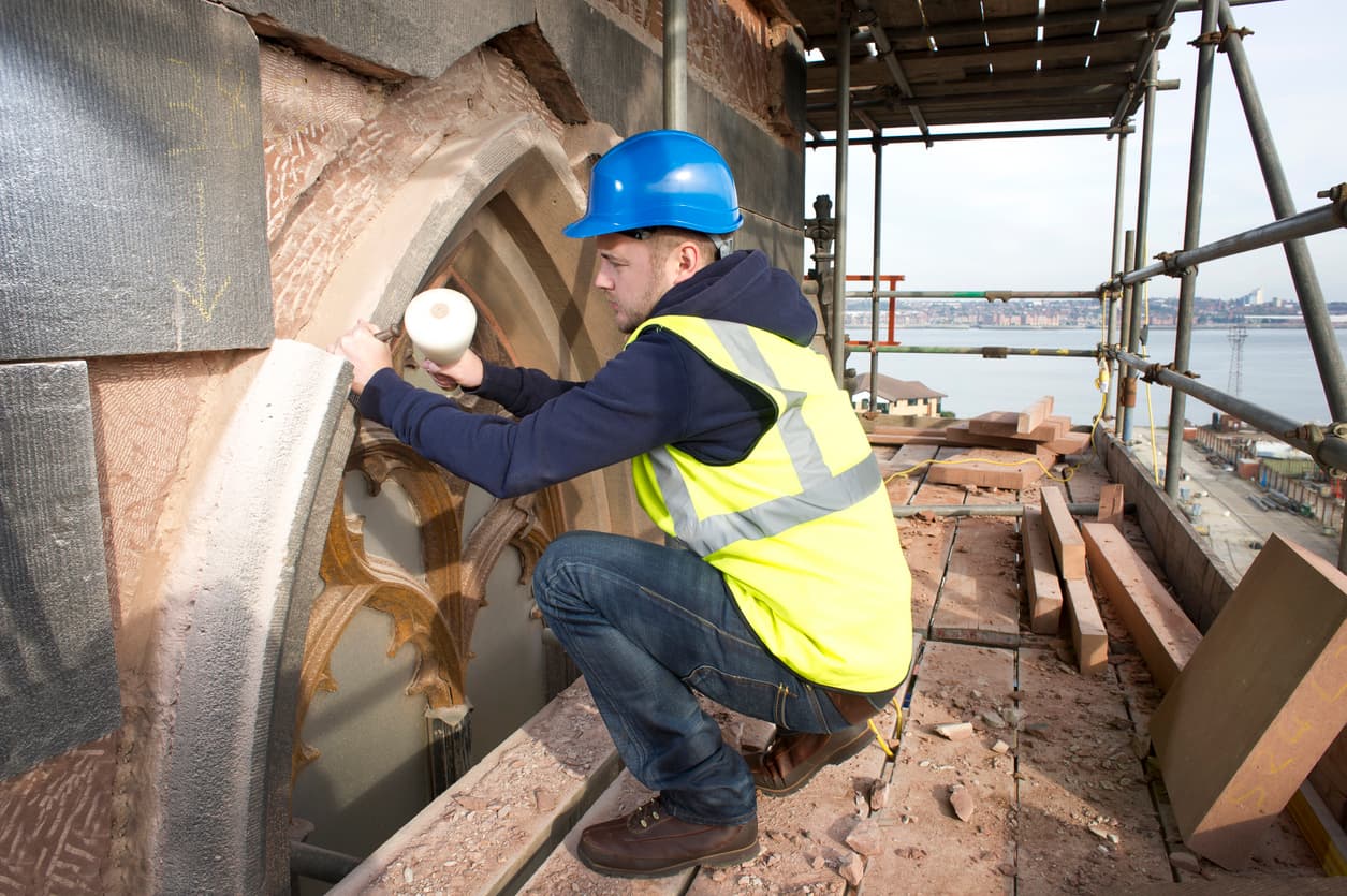 Man Working On The Exterior Of A Building
