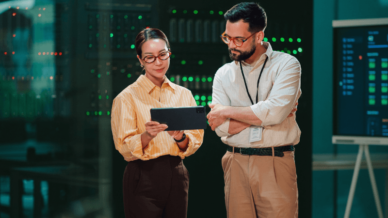 Manager Using Digital Tablet To Inspect Server Rack