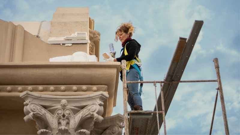 Female Artist Restoring The Facade