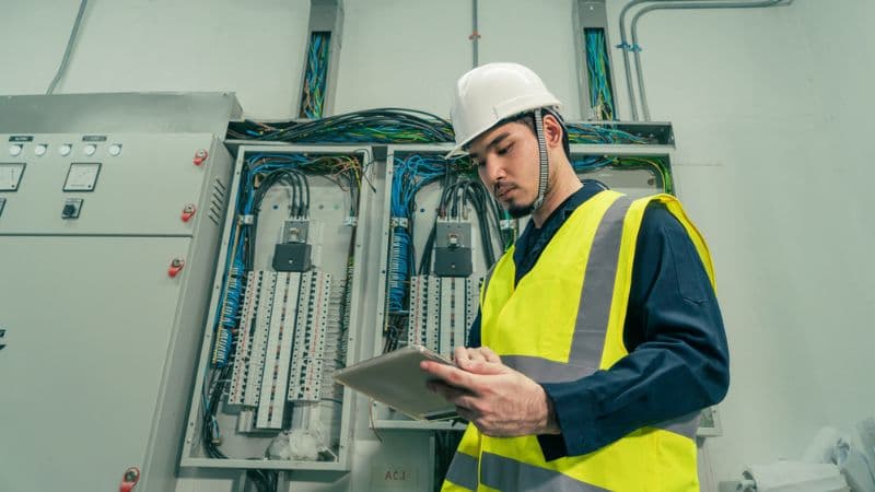 An Electrical Engineer On A Tablet In An Electrical Room